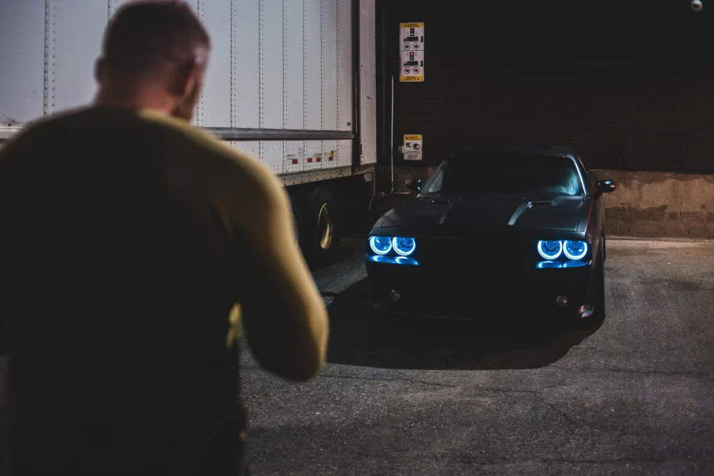 Man staring at car planning theft at night