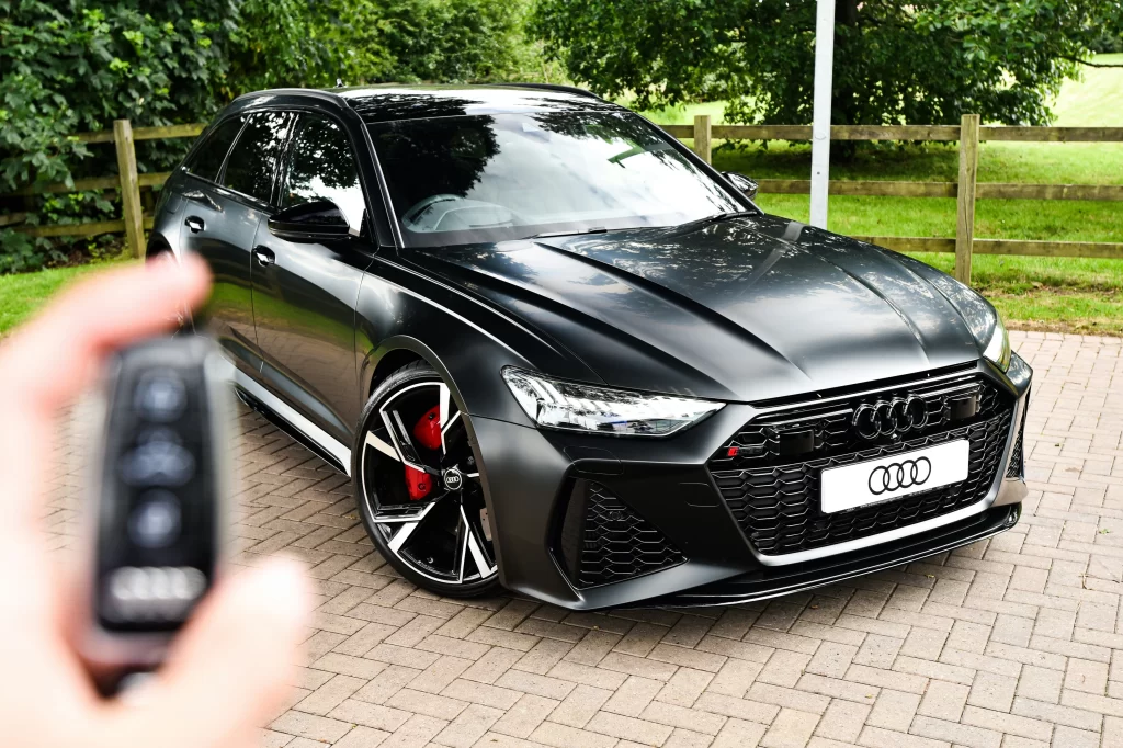 A black Audi with a blurred key in the foreground.